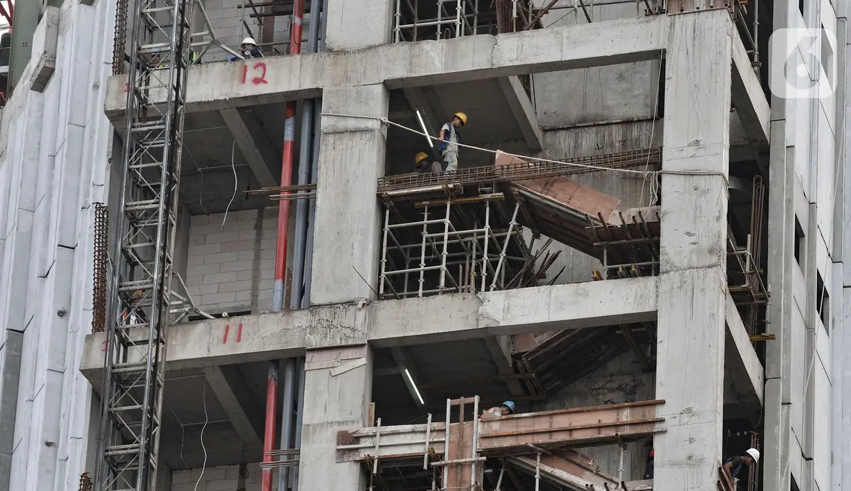 Pekerja menyelesaikan pembangunan gedung tingkat di kawasan Jalan Jenderal Sudirman, Jakarta, Selasa (21/1/2020). Kementerian Koordinator Bidang Perekonomian akan mengatur upah minimum pekerja dan rencana skema upah per jam dalam Draf RUU Omnibus Law Cipta Lapangan Kerja. (merdeka.com/Iqbal Nugroho)