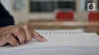 Penyandang tunanetra meraba huruf braille saat membaca buku di Perpustakaan Yayasan Mitra Netra, Jakarta, Selasa (3/12/2019). Perpustakaan Mitra Netra menyajikan buku-buku khusus penyandang tunanetra, seperti buku braille, buku audio digital, dan buku elektronik. (merdeka.com/Iqbal S Nugroho)