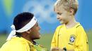 Neymar melakukan selebrasi bersama anaknya usai meraih medali emas pada final sepak bola melawan Jerman di Stadion Maracana, Rio de Janeiro, (21/8/2016) dini hari WIB. (AFP/Odd Andersen)