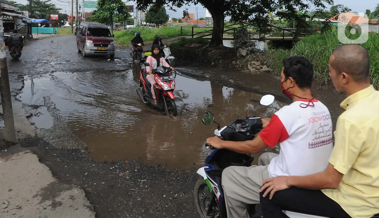 Pengendara motor menghindari lubang yang cukup dalam akibat jalan yang rusak di Jalan Raya Bojonggede, Bogor Senin (11/5/2020). Beberapa titik jalan yang menghubungkan Citayam Depok - Bojonggede Bogor mengalami kerusakan yang cukup parah sejak tiga bulan terakhir. (merdeka.com/Arie Basuki)