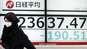 Seorang wanita berjalan melewati layar monitor yang menunjukkan indeks bursa saham Nikkei 225 Jepang dan lainnya di sebuah perusahaan sekuritas di Tokyo, Senin (10/2/2020). Pasar saham Asia turun pada Senin setelah China melaporkan kenaikan dalam kasus wabah virus corona. (AP Photo/Eugene Hoshiko)