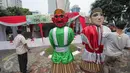 Pekerja memasang ondel-ondel di TPS 4 Kelurahan Gambir, Jalan Tanah Abang Timur, Jakarta, Selasa (18/4). Nantinya Presiden Joko Widodo akan melaksanakan pencoblosan hak suaranya pada Pilkada DKI 2017 di TPS tersebut. (Liputan6.com/Faizal Fanani)