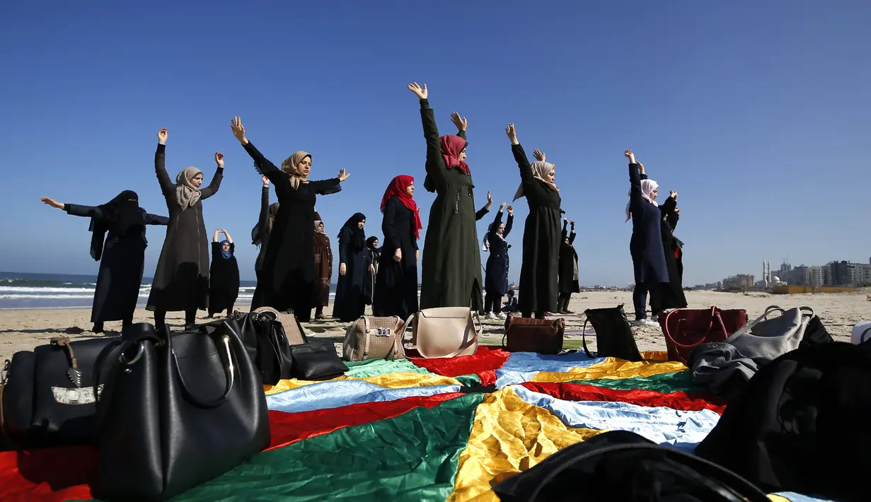 Sejumlah wanita Palestina berlatih yoga di pantai di Gaza City (3/3/2020). Pelatihan yoga tersebut diselenggarakan oleh Positive Energy Club. (AFP Photo/Mohammed Abed)