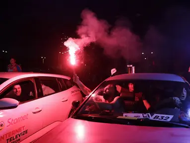 Suporter menyalakan flare saat menyaksikan pertandingan Viktoria Plzen dan Sparta Praha di sebuah bioskop drive-in di Pilsen, Republik Ceko, Rabu (27/5/2020). Di tengah pandemi COVID-19, suporter Ceko dapat menyaksikan pertandingan bola lewat layar di bioskop drive-in. (AP Photo/Petr David Josek)