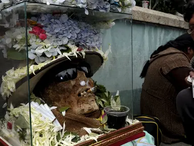 Tengkorak dengan putung rokok dimulutnya terlihat saat upacara hari tengkorak di pemakaman Umum La Paz, Bolivia, (8/11/2015).  Tiap tahun mereka berkumpul di pemakamaan untuk melakukan ritual mendoakan leluhur  mereka. (REUTERS/David Mercado)