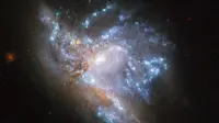 Dua galaksi bertabrakan. Momen ini direkam oleh teleskop angkasa luar Hubble milik NASA. (Adamo et al., ESA/NASA)