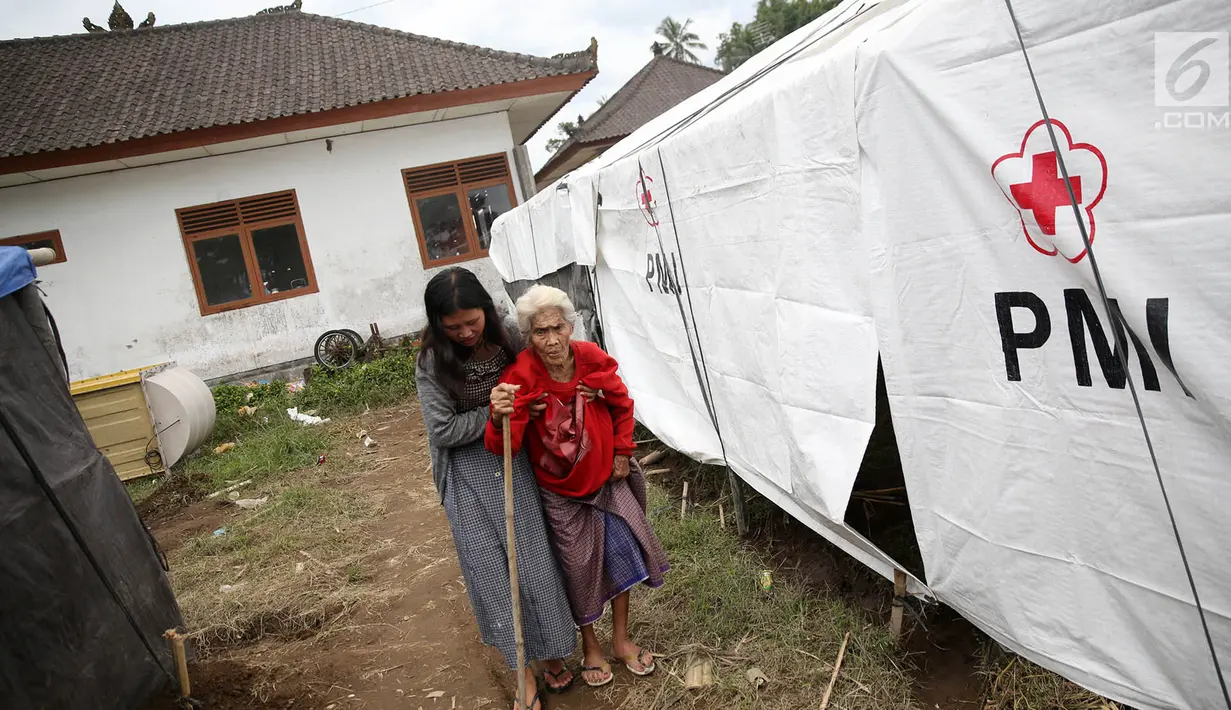 Seorang wanita lanjut usia pengungsi Gunung Agung menuju tenda kesehatan untuk memeriksakan kesehatannya di Posko Pengungsi Rendang, Bali, Sabtu (2/12). (Liputan6.com/Immanuel Antonius)