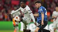 Bek Bayer Leverkusen Jeremie Frimpong berebut bola dengan bek Atalanta Matteo Ruggeri dalam laga final i Liga Europa 2023/2024 yang digelar di Aviva Stadium, Dublin, Kamis (23/5/2024) dini hari WIB. (AP Photo/Kirsty Wigglesworth)