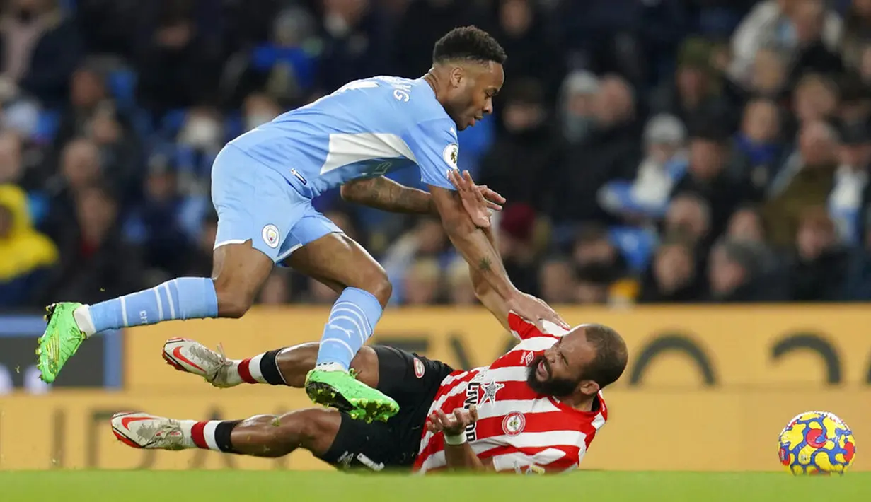 Pemain Manchester City Raheem Sterling berada di atas pemain Brentford Bryan Mbeumo pada pertandingan sepak bola Liga Inggris di City of Manchester Stadium, Manchester, Inggris, 9 Februari 2022. Manchester City menang 2-0. (AP Photo/Jon Super)