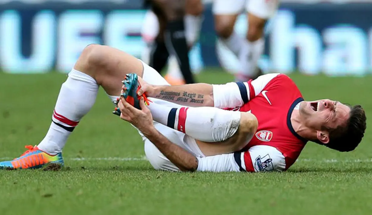 Olivier Giroud tergeletak sambil memegangi kaki kiri pada pertandingan sepak bola Liga Inggris antara Newcastle United vs Arsenal di St James 'Park, Inggris, (29/12/13). (AFP/Ian Macnicol)