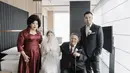 Di hari pernikahan, sang mamah tampil dengan dress merah maroon yang memiliki detail heart neck dan payetan di bagian perut. @tinatoon101