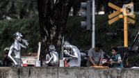 Sejumlah manusia silver bersiap untuk mencari uang di lampu merah kawasan Manggarai, Jakarta, Minggu (18/10/2020). Institute for Development of Economics and Finance (Indef) memproyeksikan angka kemiskinan di Indonesia naik pada periode September 2020. (merdeka.com/Iqbal S. Nugroho)