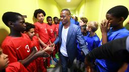 Pemain Timnas Prancis, Patrice Evra, bersama para pemain muda Les Ulis sebelum bertanding, (23/5/2016). (AFP/Franck Fife) 