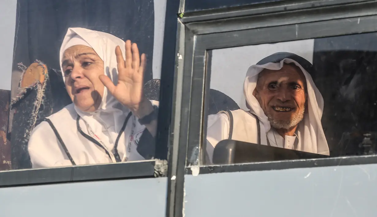 Calon jemaah haji Palestina melambaikan tangan kepada kerabatnya saat berangkat menuju Makkah di perbatasan Jalur Gaza dengan Mesir, Rafah, Kamis (25/7/2019). Seribu jemaah haji dari keluarga martir Palestina menjadi bagian dari Program Tamu Dua Mesjid Suci untuk Haji dan Umrah. (SAID KHATIB/AFP)