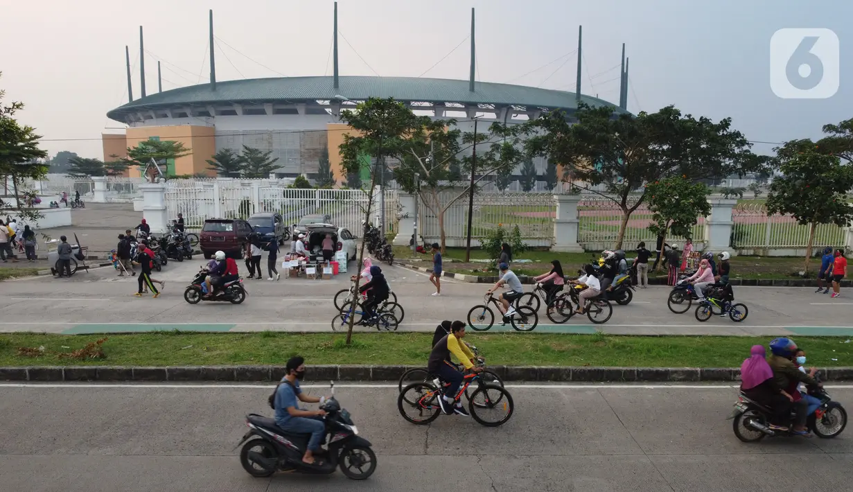 Foto udara memperlihatkan aktivitas warga di jalan lingkar kawasan Stadion Pakansari, Kabupaten Bogor, Jawa Barat, Minggu (28/6/2020). Meski area tersebut belum dibuka kembali, namun warga tetap masuk untuk melakukan beragam aktivitas di kawasan tersebut. (Liputan6.com/Helmi Fithriansyah)