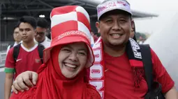Dua suporter Timnas Indonesia tersenyum saat berada di Stadion Nasional, Singapura, Jumat (9/11). Indonesia akan melawan Singapura pada laga Piala AFF 2018. (Bola.com/M. Iqbal Ichsan)