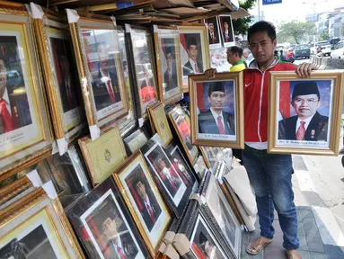 Pedagang foto resmi kenegaraan Presiden Joko Widodo atau Jokowi dan Wakil Presiden Jusuf Kalla di kawasan Pasar Baru, Jakarta, Sabtu (25/10/2014). (Liputan6.com/Miftahul Hayat)