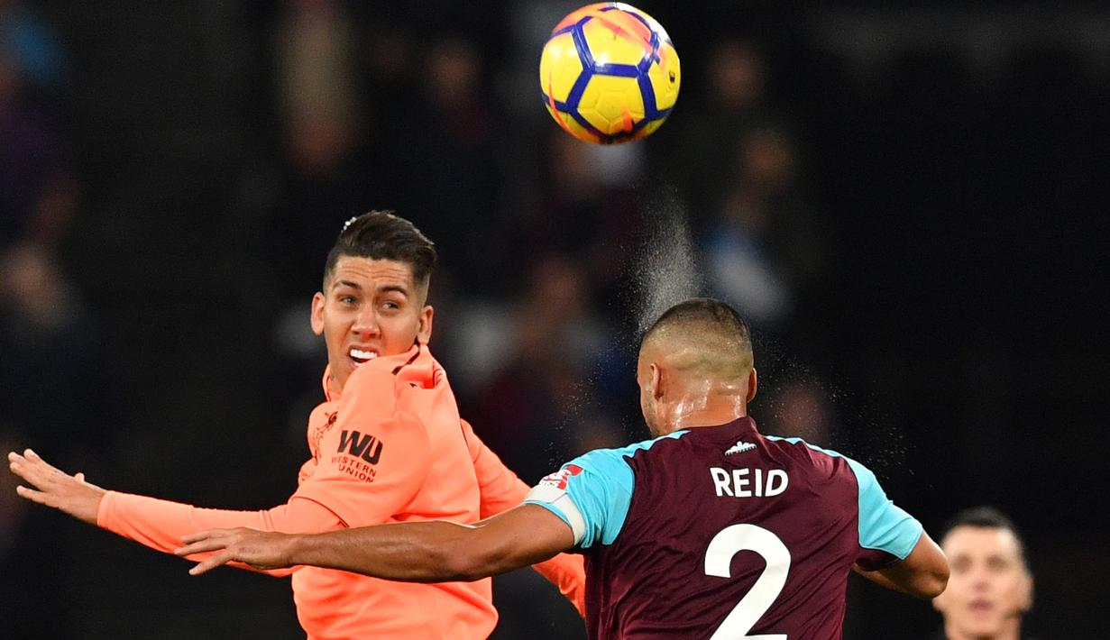 Duel pemain Liverpool, Roberto Firmino (kiri) dan pemain West Ham United, Winston Reid pada lanjutan Premier League di London Stadium, London, (4/11/2017). Liverpool menang 4-1. (AFP/Ben Stansall)
