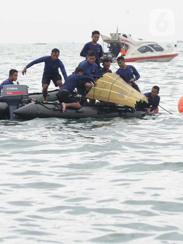 Tim SAR mengevakuasi bagian tubuh penumpang pesawat Sriwijaya Air SJ 182 di perairan Kepulauan Seribu, Jakarta, Minggu (10/1/2021). Sriwijaya Air SJ 182 hilang kontak empat menit usai lepas landas dari Bandara Soetta. (merdeka.com/Arie Basuki)