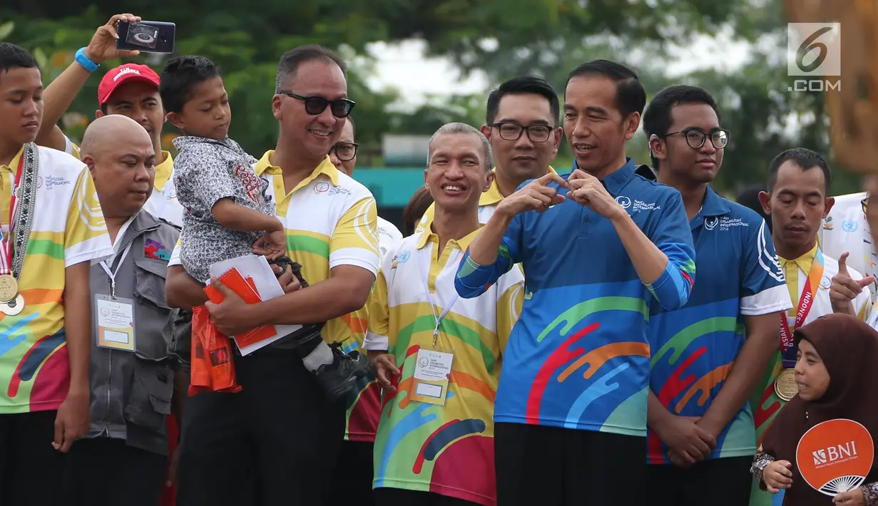 Presiden Joko Widodo menghadiri peringatan Hari Disabilitas Internasional 2018 di Bekasi, Jawa Barat, Senin (3/12). Jokowi bertemu Muklis Abdul Kholik yang sempat viral karena semangatnya untuk bersekolah. (Liputan6 com/Angga Yuniar)