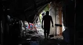 Warga berjalan melewati puing-puing rumah yang rusak akibat gempa di General Santos, Filipina, Selasa 9 Juni 2026. (AP Photo/Basilio Sepe)