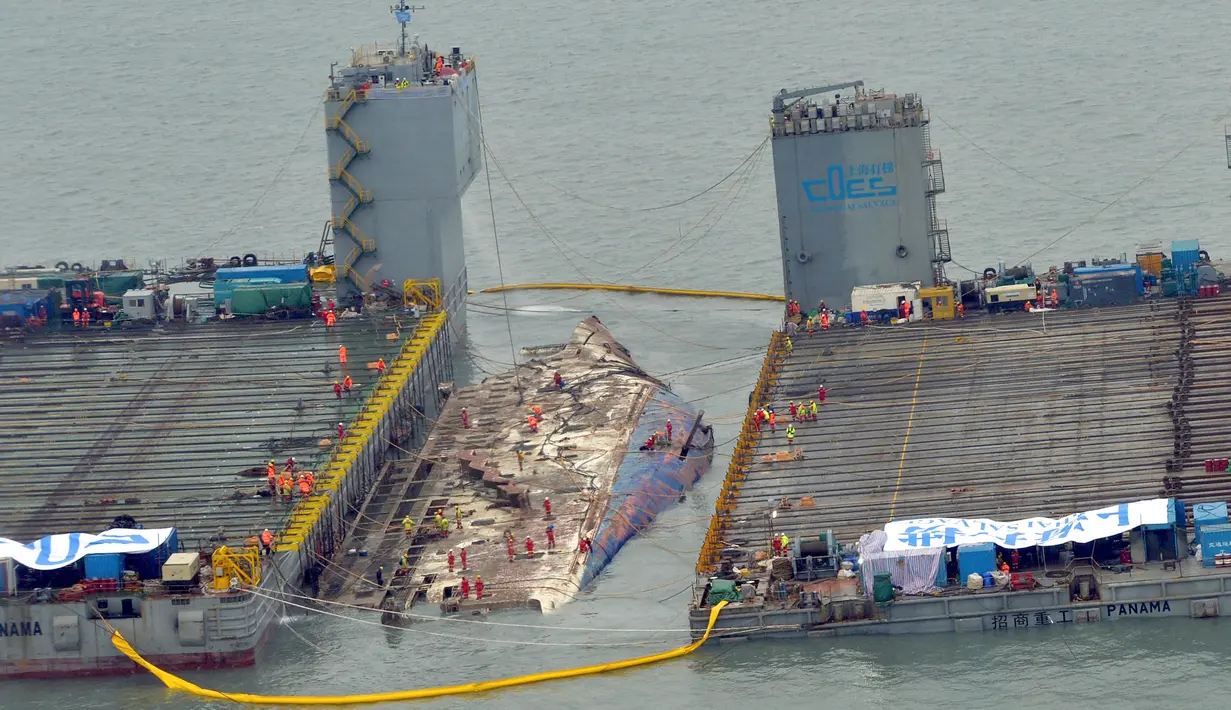 Pekerja mempersiapkan diri mengangkat bangkai kapal feri Sewol di pulau barat daya Jindo, Korea Selatan, Kamis (23/3).Feri Sewol yang tenggelam hampir tiga tahun lalu dari kedalaman 44 meter muncul untuk pertama kalinya (Park Gyung-woo/Hankookilbo via AP)