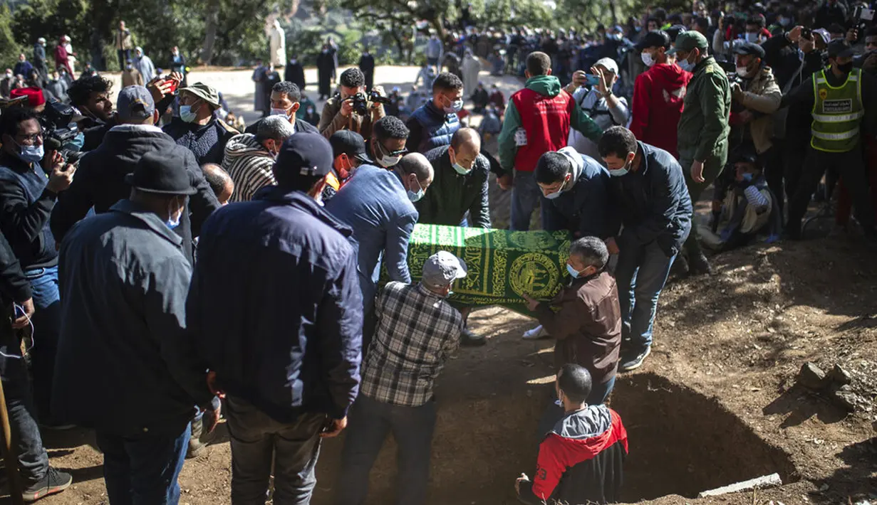 Peti jenazah Rayan Oram (5) diturunkan ke dalam makam saat pemakamannya di Desa Ighran, Provinsi Chefchaouen, Maroko, 7 Februari 2022. Rayan Oram meninggal setelah terjebak selama lima hari dalam sumur kering sedalam 32 meter. (AP Photo/Mosa'ab Elshamy)