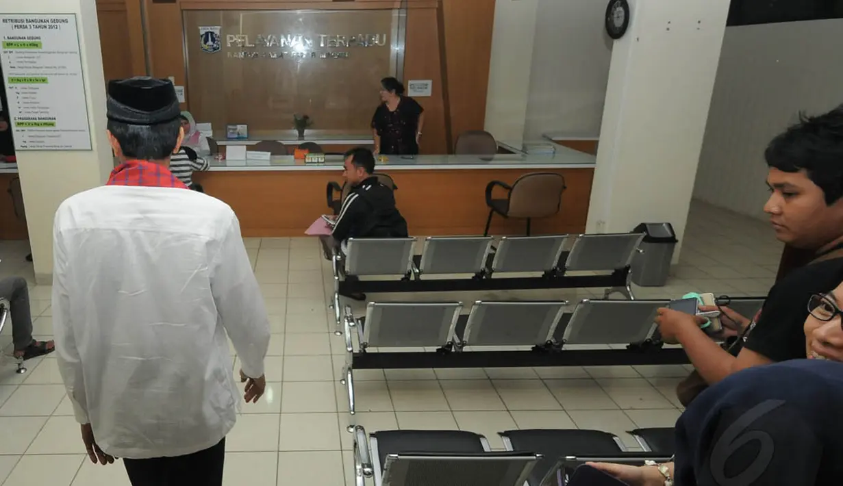 Jokowi yang mengenakan baju koko putih dan sarung merah yang dikalungkan di leher, datang sekitar pukul 11.00 WIB dan langsung masuk ke ruang tunggu kantor Kecamatan Pasar Minggu, Jakarta, Jumat (23/5/14). (Liputan6.com/Herman Zakharia)