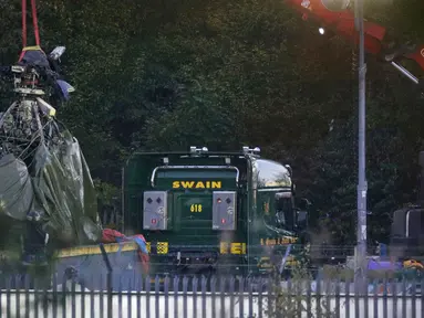 Crane mengevakuasi bangkai helikopter dari lokasi kecelakaan yang menewaskan pemilik Leicester City Vichai Srivaddhanaprabha di Leicester, Inggris, Kamis (1/11). Kondisi helikopter terlihat rusak parah dengan bekas terbakar api. (Aaron Chown/PA via AP)