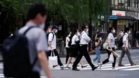 Orang-orang mengenakan masker mencegah penyebaran coronavirus baru berjalan di atas penyeberangan pejalan kaki di Tokyo, Senin, (20/7/2020). Ibukota Jepang hari Senin mengkonfirmasi lebih dari 160 kasus virus corona baru. (AP Photo/Eugene Hoshiko)