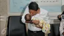 Kombes Krishna Murti mencium bayi saat memberi keterangan pers terkait sindikat penjualan bayi di Polda Metro Jaya, Jakarta, Selasa (1/3/2016). Sebelumnya, Senin (29/1) polisi menangkap 4 pelaku penculikan dan jual beli anak. (Liputan6.com/Johan Tallo)