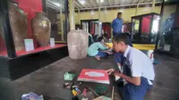 Salah seorang pelajar SMP sedang melukis guci di Museum Sadurangas, Senin (18/7/2022). (Liputan6.com)