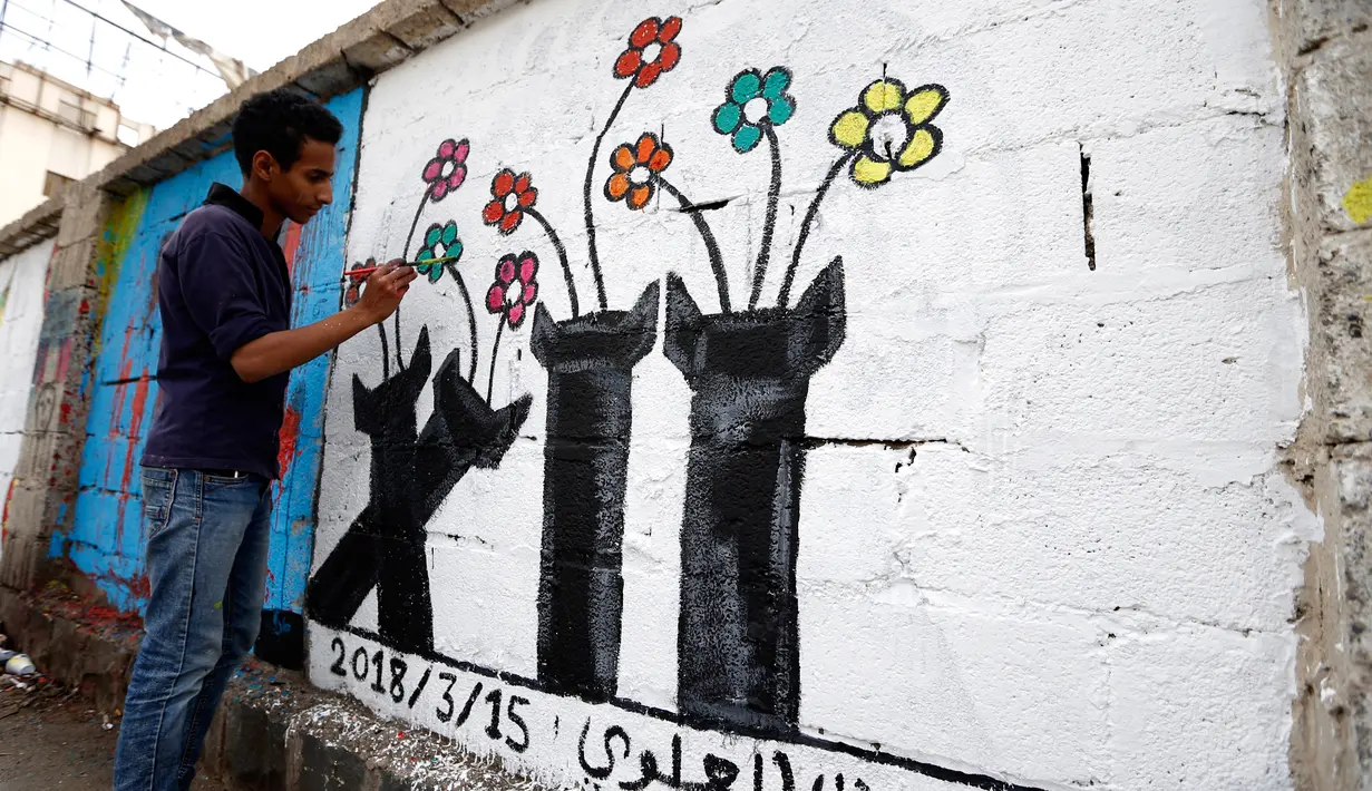 Seorang seniman melukis grafiti pada dinding di Ibu Kota Sanaa, Yaman, Kamis (15/3). Kampanye ini untuk mendukung perdamaian di negara yang terkena dampak perang. (Mohammed HUWAIS/AFP)