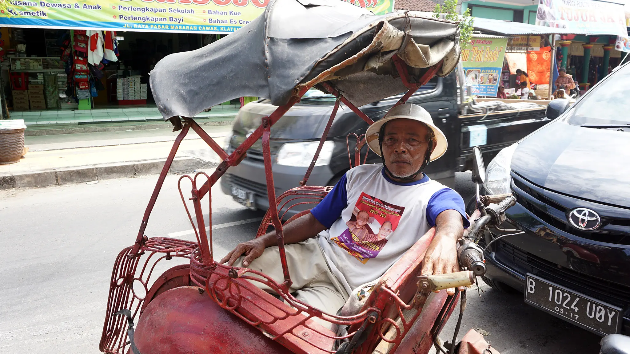 Penarik becak asal Klaten, Mbah Pairo sedang menunggu penumpang di Pasar Cawas Klaten, Rabu (2/8).(Liputan6.com/Fajar Abrori)