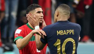 Bek Maroko Achraf Hakimi dihibur oleh penyerang Prancis Kylian Mbappe usai pertandingan semifinal Piala Dunia 2022 di Stadion Al-Bayt di Al Khor, Doha, Kamis (15/12/2022). Maroko gagal melaju ke final Piala Dunia 2022 Qatar setelah kalah dari Prancis dengan skor 2-0. (AFP/Karim Jaafar)