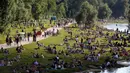 Ribuan orang menikmati cuaca musim panas di tepi sungai 'Isar' di Munich, Jerman (19/7/2020). Di tengah pandemi COVID-19, ribuan orang menikmati cuaca musim panas di dekat sungai tersebut untuk berjemur serta mendinginkan tubuh. (AP Photo/Matthias Schrader)