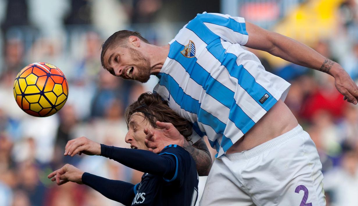 Duel antara pemain Real Madrid, Luka Modric (kiri), dengan pemain Malaga, Raul Albentosa, dalam laga La Liga Spanyol di Estadio La Rosaleda, Minggu (21/2/2016) malam WIB. (AFP/Jorge Guerrero)