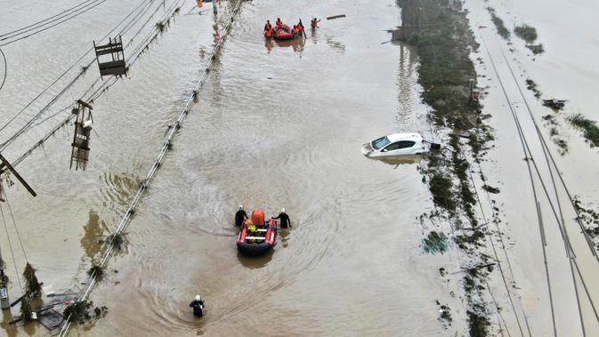 Foto udara menunjukkan penduduk dievakuasi dengan perahu menyusul hujan lebat di Kumamura, prefektur Kumamoto, Jepang,  Minggu (5/7/2020). Banjir yang memicu tanah longsor ini telah menghancurkan ratusan rumah dan kendaraan serta membuat jembatan antar kota terputus. (Koji Harada/Kyodo News via AP)