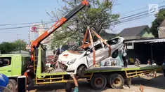 Petugas derek mengevakuasi bangkai mobil kecelakaan maut yang hancur tertindih badan truk muatan tanah di Karawaci, Tangerang, Kamis (1/8/2019). Lima orang penumpang minibus menjadi korban, empat diantaranya meninggal dan satu balita berhasil diselamatkan warga. (Liputan6.com/Pramita Tristiawati)