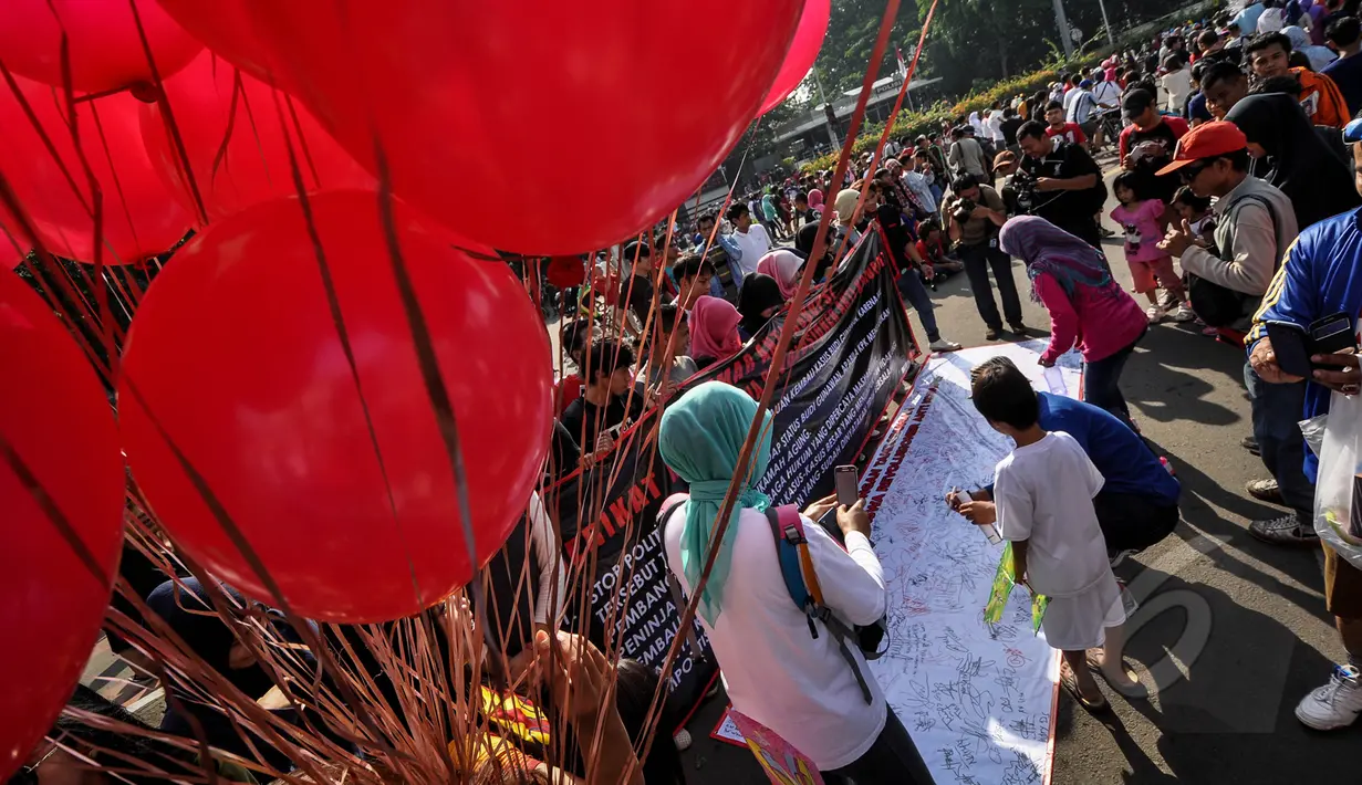 Massa yang mengatasnamakan Serikat Mahasiswa Revolusioner melakukan aksi demonstrasi di Bundaran HI, Minggu (4/4/2015). Padahal, Pemprov DKI sudah melarang adanya kegiatan yang bernuansa politik selama CFD berlangsung. (Liputan6.com/Faizal Fanani)