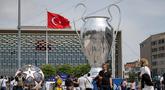 Pejalan kaki berjalan di dekat balon trofi Liga Champions  di Taksim Square di Istanbul, pada 8 Juni 2023. (AFP/Yasin Akgul)
