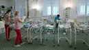 Perawat merawat bayi yang baru lahir dari skema ibu pengganti (surrogate mother) di Hotel Venice, Kiev, Ukraina, 15 Mei 2020. Para orangtua bayi tersebut belum dapat masuk ke Ukraina karena terkendala larangan bepergian. (Sergei SUPINSKY/AFP)