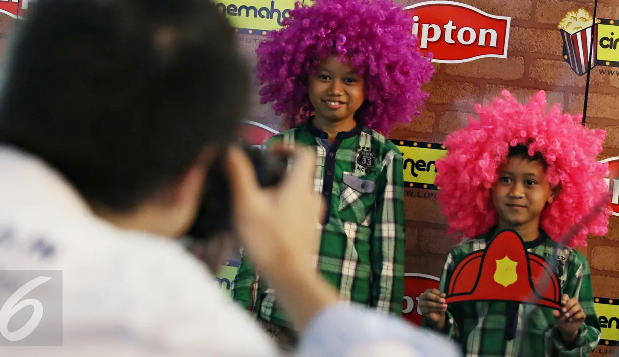 Pengunjung berpose di photobooth yang telah disiapkan panitia nobar film di Blitz Grand Indonesia, Jakarta, Sabtu (7/11/2015). Cinemaholic Secret Agent bersama Lipton menyajikan beragam kegiatan menarik. (Liputan6.com/Immanuel Antonius)
