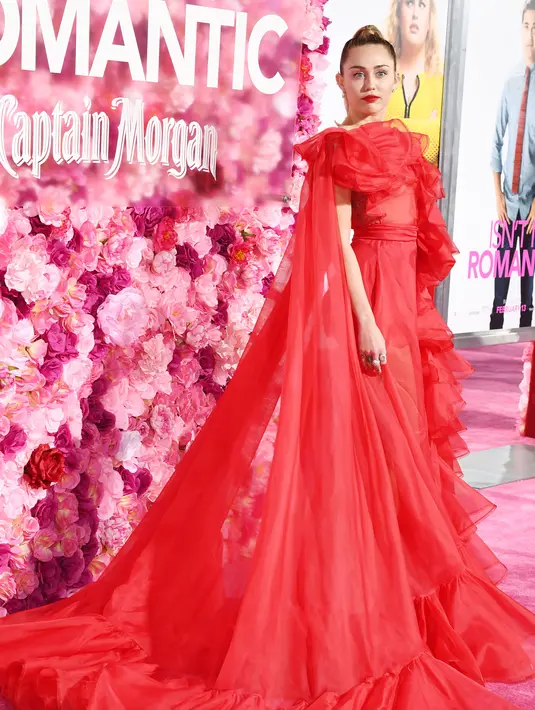 Penyanyi dan artis Hollywood, Miley Cyrus berpose saat tiba menghadiri pemutaran perdana film "Isn't It Romantic" di Los Angeles (11/2). Miley Cyrus tampil cantik dalam gaun panjang Maison Valentino berwarna merah. (AFP Photo/Amy Sussman)
