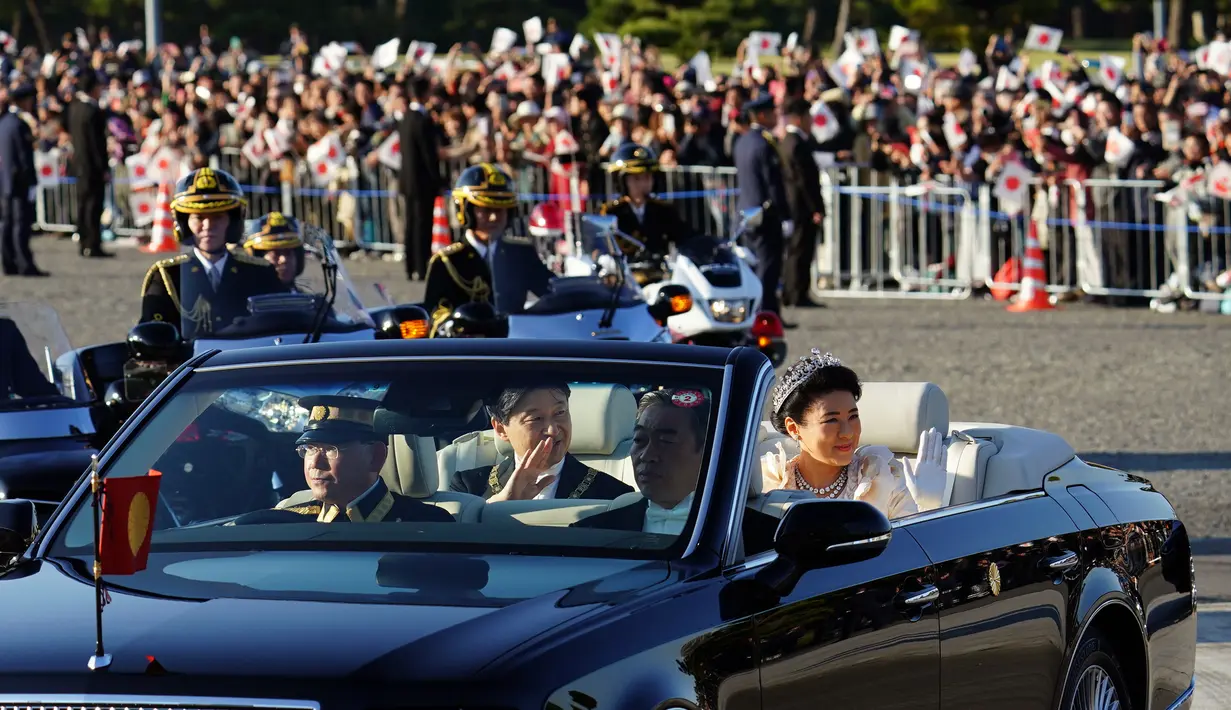 Kaisar Jepang, Naruhito dan Permaisuri Masako menyapa warganya selama parade di Tokyo, Jepang, Minggu (10/11/2019). Parade digelar dalam rangka mengakhiri serangkaian acara penobatan Kaisar Naruhito sejak 1 Mei 2019, atau sehari setelah Akihito turun takhta. (AP Photo/Eugene Hoshiko)