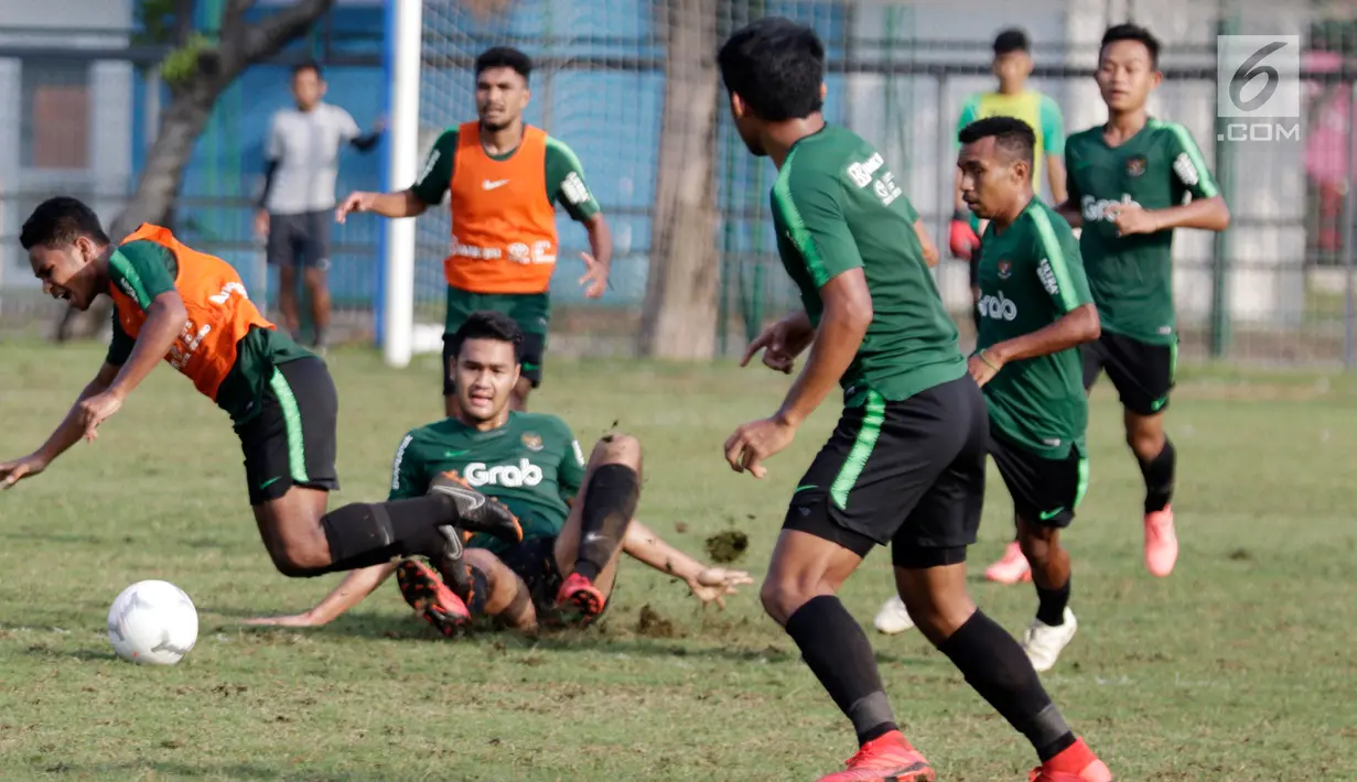 Pemain Timnas Indonesia U-22, Rafi Syarahil terjatuh saat berebut bola di Lapangan ABC, Senayan, Jakarta, Sabtu (12/1). Pada hari keenam pemusatan latihan, Indra Sjafri menggelar game internal untuk menyaring para pemainnya. (Bola.com/M Iqbal Ichsan)