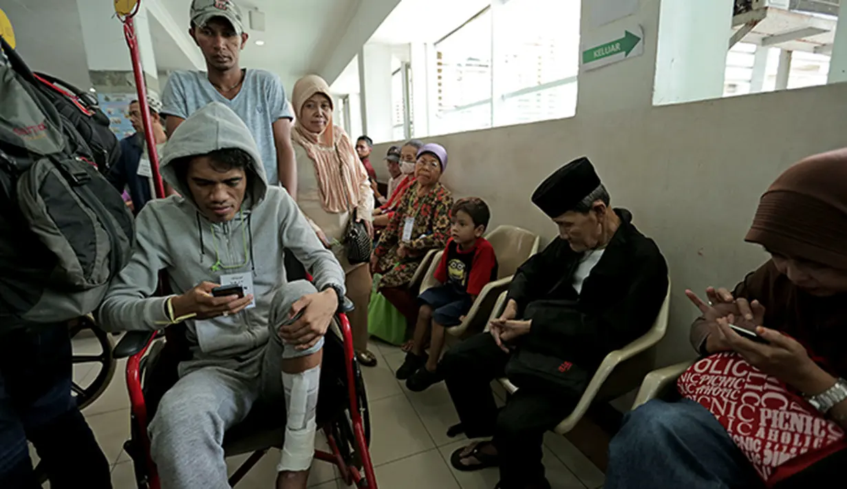 Alfin Tuasalamony membuang rasa jenuh menanti giliran waktu berkonsultasi dengan dokter.  (Bola.com/Peksi Cahyo)