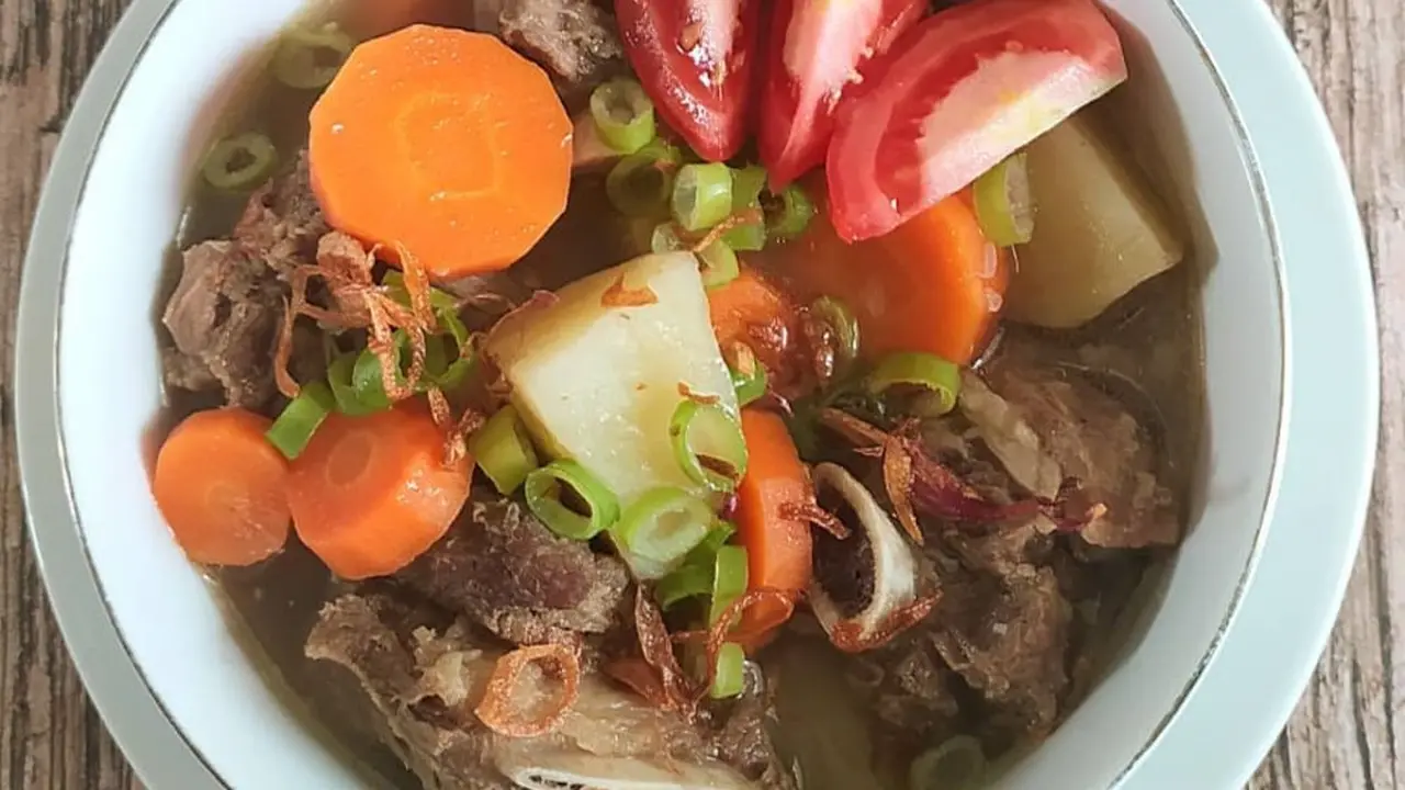 Semangkuk sop iga sapi dengan tomat dan wortel