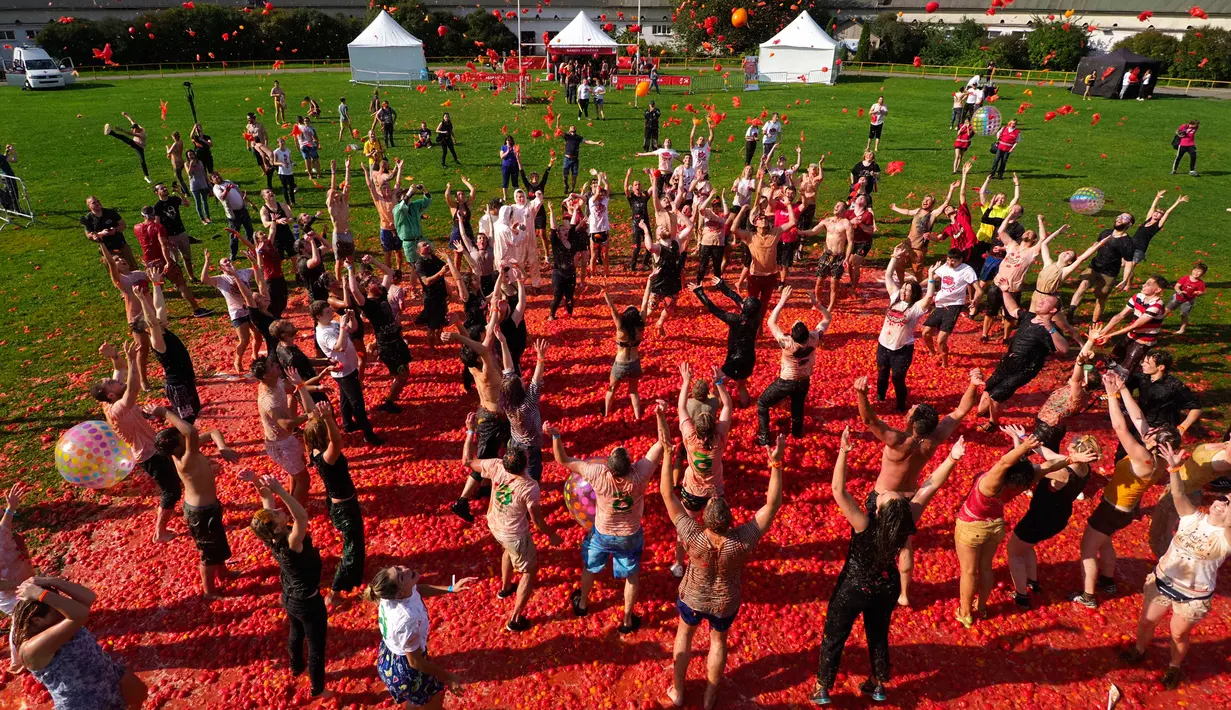 Orang-orang saling melempar tomat ketika berpartisipasi dalam festival 'Tomatina' atau perang tomat di St.Petersburg, Rusia, Minggu (18/8/2019). Tomatina atau perang tomat adalah festival Spanyol, dan tahun ini merupakan pertama kalinya dirayakan di Rusia. (AP Photo/Dmitri Lovetsky)