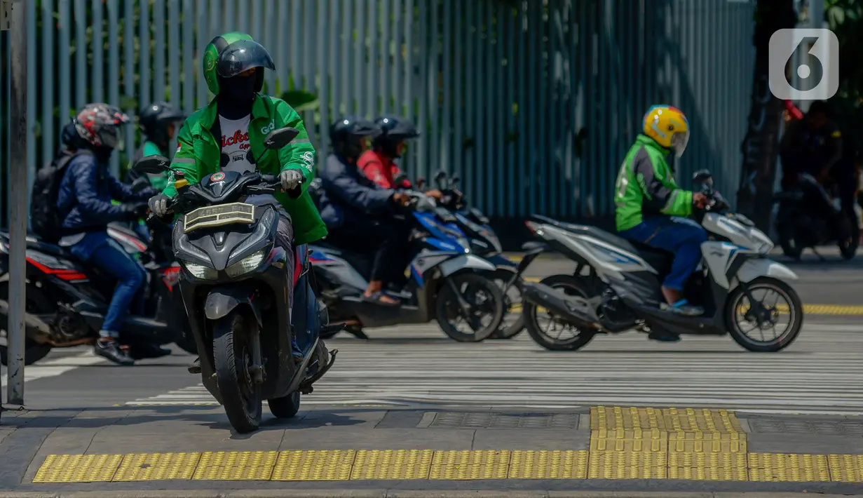 Pengendara motor melintas di atas trotoar di perempatan Sarinah, Thamrin, Jakarta, Rabu (29/1/2020). Direktorat Lalu Lintas Polda Metro Jaya akan memberlakukan tilang elektronik "Electronic Traffic Law Enforcement" (ETLE) untuk sepeda motor per 1 Februari 2020. (merdeka.com/Imam Buhori)